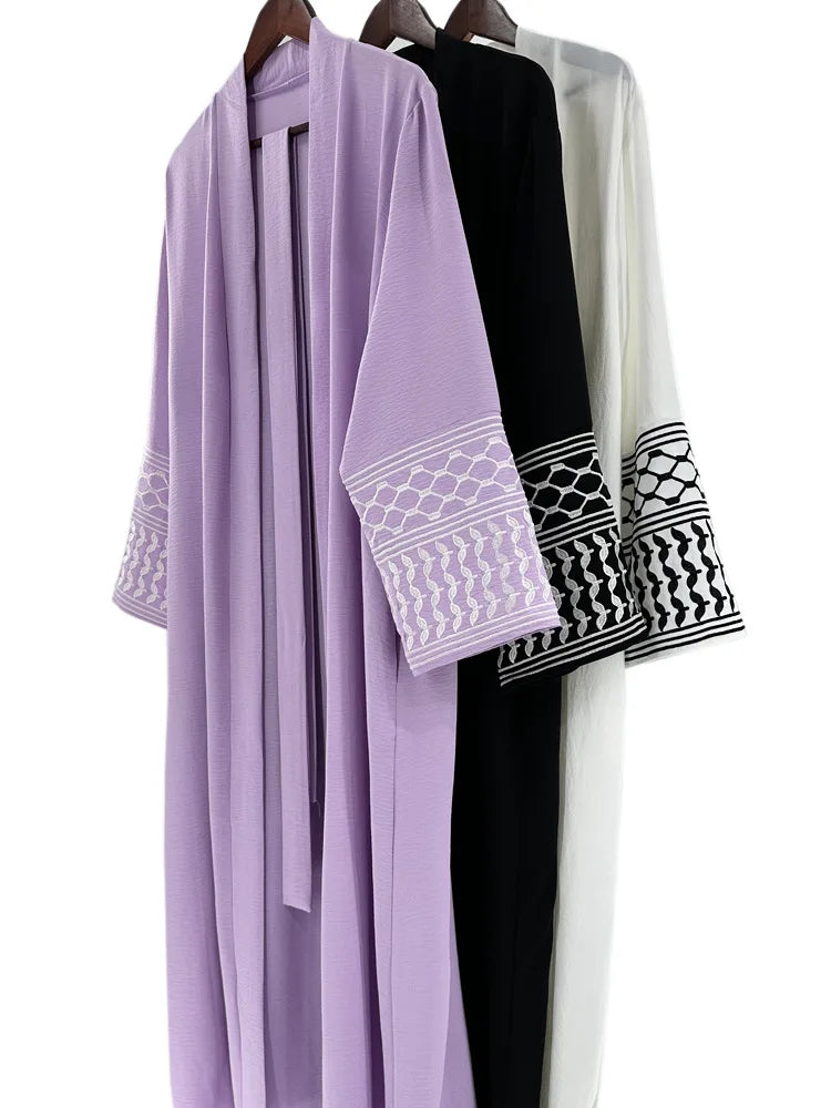 Kuffiyeh-inspired abaya with embroidered sleeves and detachable belt.