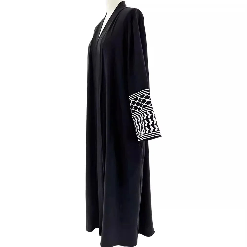 Kuffiyeh-inspired abaya with embroidered sleeves and detachable belt.